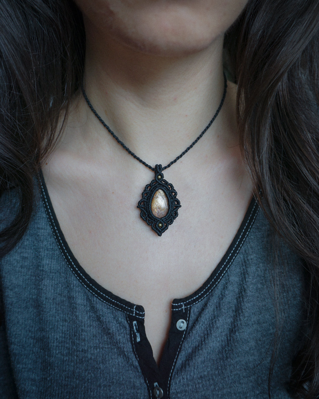 collana pendente fatta a mano in macrame colore nero con pietra del sole naturale e perline bronzo